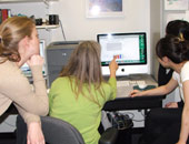 Staff gathered around computer reviewing data
